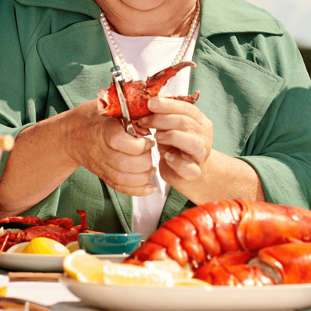 Person breaking down a lobster claw Person breaking down a lobster claw