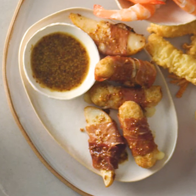 Maple mustard glazed prosciutto wrapped cheese sticks and pears