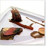Carré d’agneau farci aux légumes-racines, quatre-quarts parmesan et olives, caviar d’aubergine et jus de cuisson