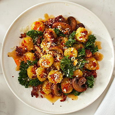 Casserole de gnocchis grillés avec saucisse, champignons et chou frisé