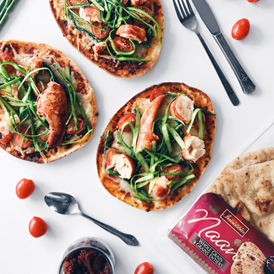 Pizza sur pain naan au homard, tomates, asperges et fromage cheddar