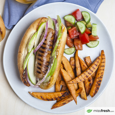 Subs de saucisse grillée avec salade de pommes et quartiers de patate douce avec salade de tomates et de concombre